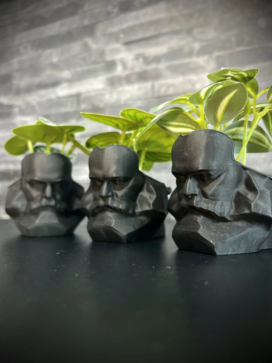 Drei schwarze Karl-Marx-Blumentöpfe mit grünen Pflanzen – handgefertigtes Chemnitz Souvenir