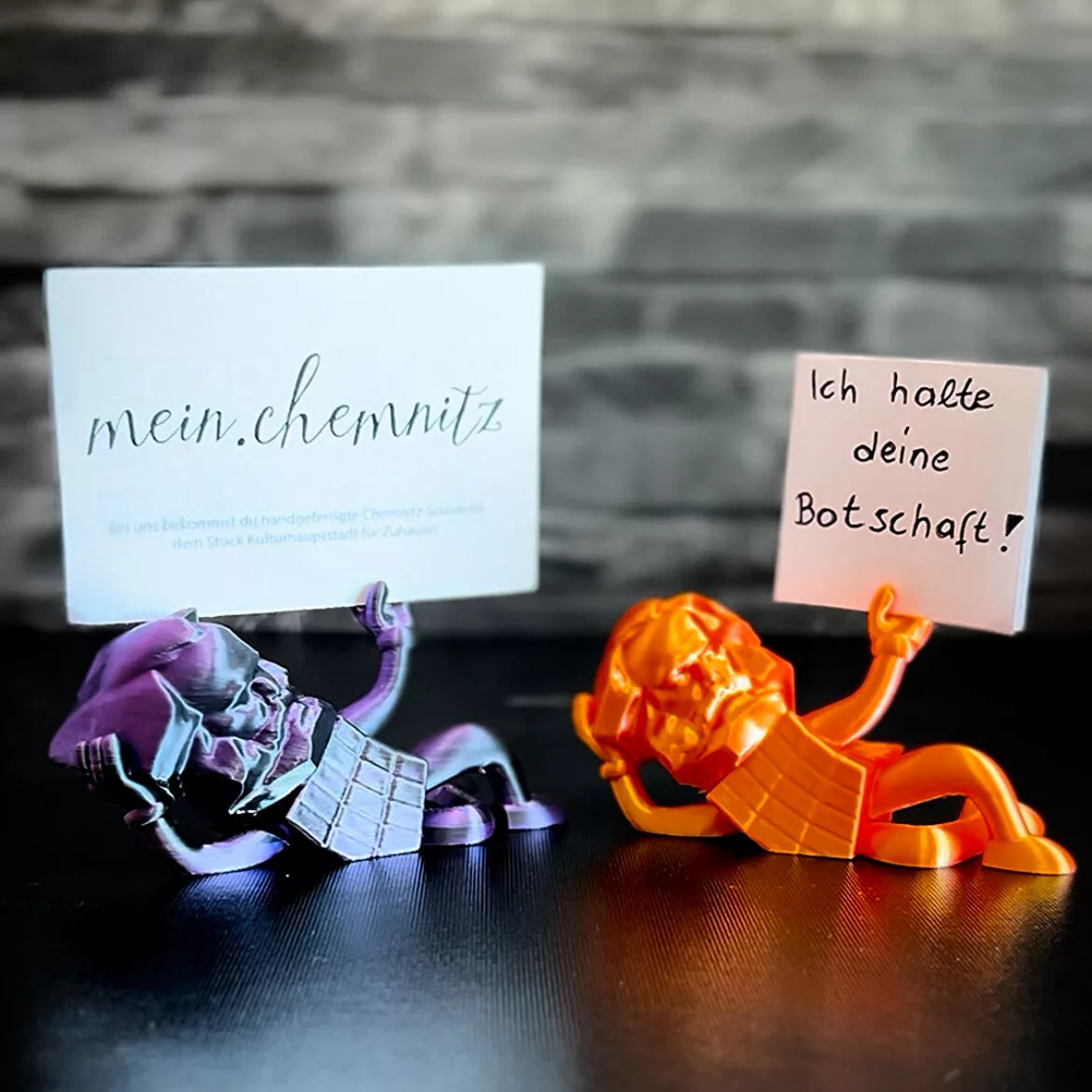 Chemnitzer Karl Marx Miniatur hält Geschenke, wie Geldscheine oder kleine Nachrichten. 